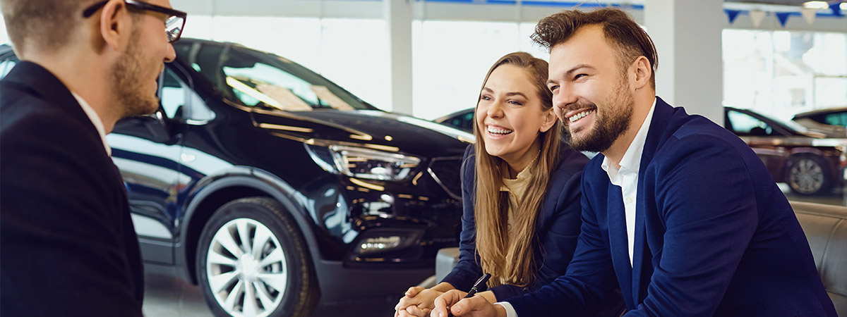 Family speaking with car dealer